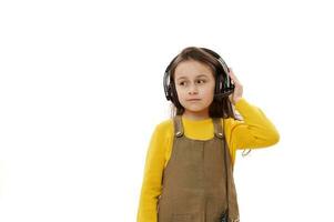 bezaubernd primär Schule Student, 5-6 Jahre schön wenig Kind Mädchen mit Audio- Headset, isoliert Über Weiß Hintergrund foto