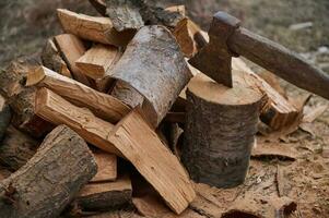 Nahansicht Holzverbrennung Axt und Brennholz zum das Winter im ein rustikal Stil. Schneiden Holz im das Wald zum Feuer Hitze foto