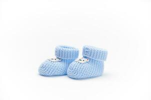 ein Paar von handgemacht Blau gestrickt Baby Stiefeletten, isoliert auf Weiß Hintergrund. Neugeborene Kleidung und Schwangerschaft. Mode foto