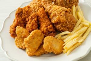 Brathähnchen mit Pommes Frites und Nuggets auf Teller foto