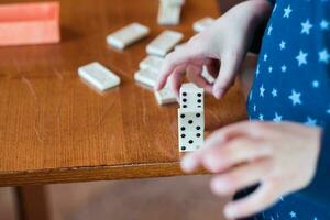 Junge spielen mit Domino, schließen hoch. bauen ein Domino Zaun, schließen oben foto