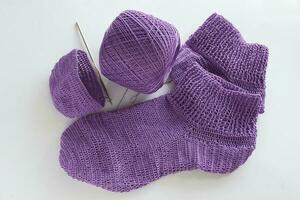 Socken gemacht von lila Garn. es ist ein Kunst Das ist Beliebt unter jene Wer Liebe Stricken mit häkeln. foto