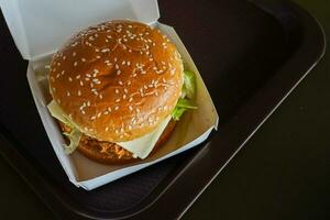 köstlich schnell Essen saftig Cheeseburger im ein Weiß Papier Box Feeder foto