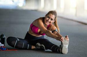 Fitness, Sport, ausüben und Lebensstil Konzept - - schließen oben von Paar Dehnen Bein . schön jung Mädchen Dehnen ihr Kniesehnen. Foto von sportlich Mädchen tun trainieren.