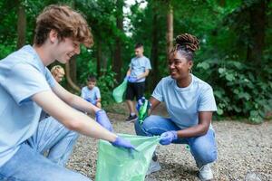 ein Gruppe von Menschen sind Reinigung zusammen im ein Öffentlichkeit Park, schützen das Umfeld. Frau im das Vordergrund mit ein Müll Tasche im ihr Hand reinigt das Park foto