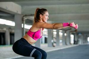 sportliche frau, die mit hanteln trainiert. Foto einer aktiven Frau in Sportbekleidung beim Training. dynamische Bewegung. Seitenansicht. Sport und gesunder Lebensstil