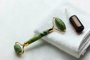 Grün Jade Walze Massagegerät zum Gesicht auf Weiß Marmor. foto