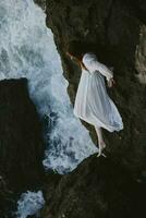 schön jung Frau im ein Weiß Kleid Lügen auf ein Stein im ein Weiß Kleid unverändert foto