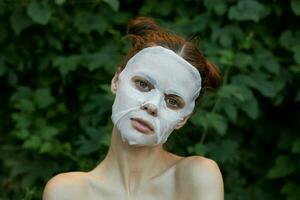 Porträt von ein Mädchen kosmetisch Maske aussehen voraus und Gebüsch im das Park Kosmetologie foto