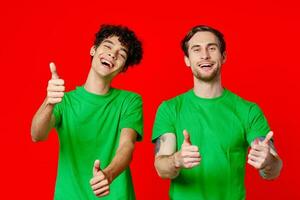 zwei heiter freunde von Grün T-Shirts gestikulieren mit Hände Emotionen foto