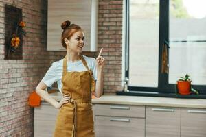 ziemlich Frau im ein Schürze im das Küche Hausarbeit Lebensstil foto