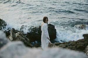 Frau Reisender im Weiß Kleid beim das Meer Strand Natur foto