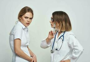 ein empört geduldig kommuniziert mit ein Krankenschwester im ein medizinisch Kleid und ein Spritze im ihr Hand foto