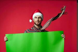 emotional Mann im ein Santa Hut halten ein Banner Urlaub isoliert Hintergrund foto