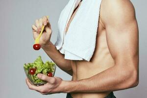 ein Mann mit ein Handtuch auf seine Schultern ein Teller von Salat gesund Essen Diät foto