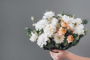 weiblich Hand hält schön Strauß von Chrysanthemen. Mütter Tag, Urlaub Dekor, Blume Lieferung Konzept. generativ ai Illustration foto