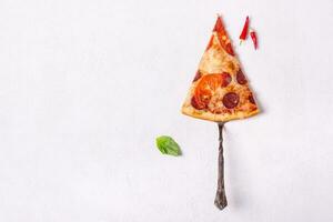 Stück von Peperoni Pizza mit Würste und Tomate auf Weiß Hintergrund foto