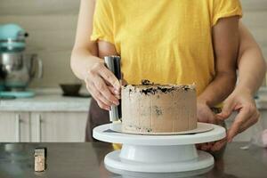 Frauen Paar Herstellung Schokolade Kuchen im Küche, Nahansicht. Kuchen Herstellung Verfahren, selektiv Fokus foto