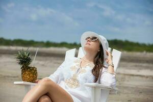 Frau entspannend beim ein paradiesisch tropisch Strand im ein schön sonnig Tag foto