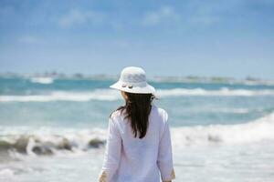 Frau Gehen beim ein leeren paradiesisch tropisch Strand im ein schön sonnig Tag foto