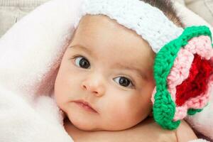 Süss vier Monate Baby Mädchen tragen ein gehäkelt Stirnband foto