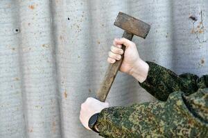 ein Vorschlaghammer im das Hände von ein Mann. ein groß Hammer im seine Hände. foto