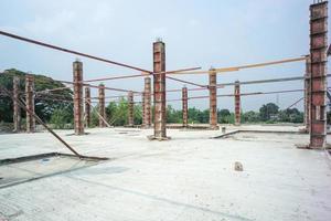 Perspektive der Betonsäulen im Stahlmodell, das auf dem Zementboden auf der Baustelle mit klarem Himmelhintergrund steht foto