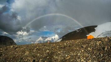 atmosphärisch alpin Landschaft mit schneebedeckt Berge mit Regenbogen ich foto