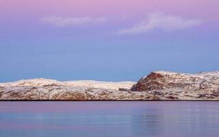 tolle Sonnenuntergang Polar- Landschaft mit Weiß schneebedeckt Berg Angebot auf das Horizont. Arktis Ozean Panorama- Aussicht foto