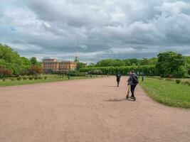 ein Teenager Reiten ein Roller im ein Stadt Park foto