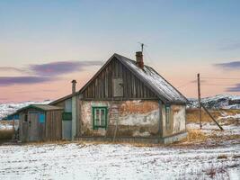 ein alt Haus mit ein Leiter zu das Dachgeschoß. authentisch Russisch Nord Dorf, hart Arktis Natur. foto