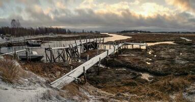 niedrig Tide. Angeln Seebrücke im das authentisch Nord Dorf von umba. Kola Halbinsel foto