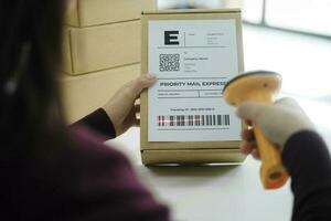 weiblich online Geschäft Inhaber Scan Versand Etikette auf Paket. foto