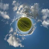 grüner winziger Planet im blauen Himmel mit schönen Wolken mit Transformation des sphärischen Panoramas 360 Grad. Krümmung des Raumes. foto