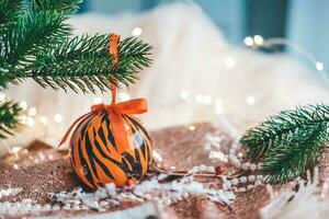 Weihnachten Bälle gemalt wie Tiger Streifen auf Weihnachten Baum mit ein Girlande. 2022 ist ein Jahr von das Tiger. glücklich Neu Jahr . Symbol von Jahr Mond- Chinesisch Kalender Tiger auf Weihnachten Ball . foto