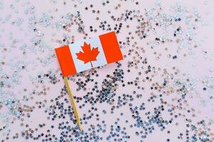 Kanada Flagge und funkelt auf Rosa Hintergrund, eben legen. Urlaub im Kanada. 1 von Juli, Kanadas glücklich Unabhängigkeit Tag. foto