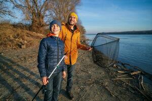 Vater und Sohn sind Angeln auf sonnig Winter Tag foto