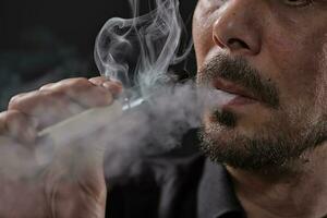 ein Mann Rauchen ein elektronisch Zigarette foto