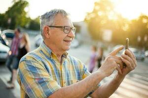 Senior Mann nehmen ein Foto mit seine Telefon