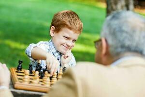 ein Großvater und seine Enkel spielen Schach foto