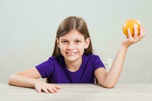 ein Mädchen Essen ein Orange foto