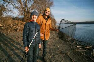 Vater und Sohn sind Angeln auf sonnig Winter Tag foto