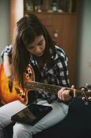 ein Teenager Mädchen spielen Gitarre foto