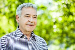 Porträt von ein Senior Mann auf das Park foto