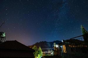Sterne und Milchstraße über dem Wald und ein Haus in den Troodos-Bergen
