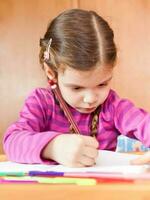 ein kleines Mädchen zeichnet foto