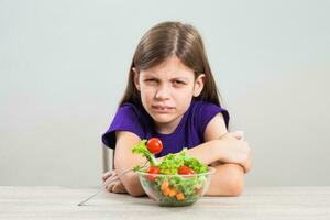 ein Mädchen Essen ein Salat foto