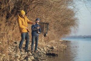 Vater und Sohn sind Angeln auf sonnig Winter Tag foto