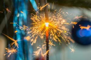 Verbrennung Wunderkerze mit Menge von hell Funken beim das Weihnachten Baum foto