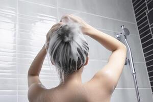 Frau Waschen Haar mit Shampoo und Dusche im das Badezimmer. ai generiert foto